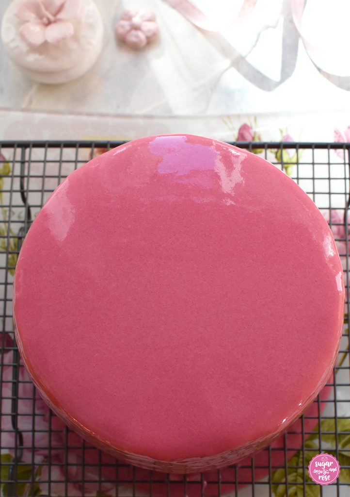 Mirror Glaze in Rosa auf Torte, die auf einem Gitter zum Abtropfen steht