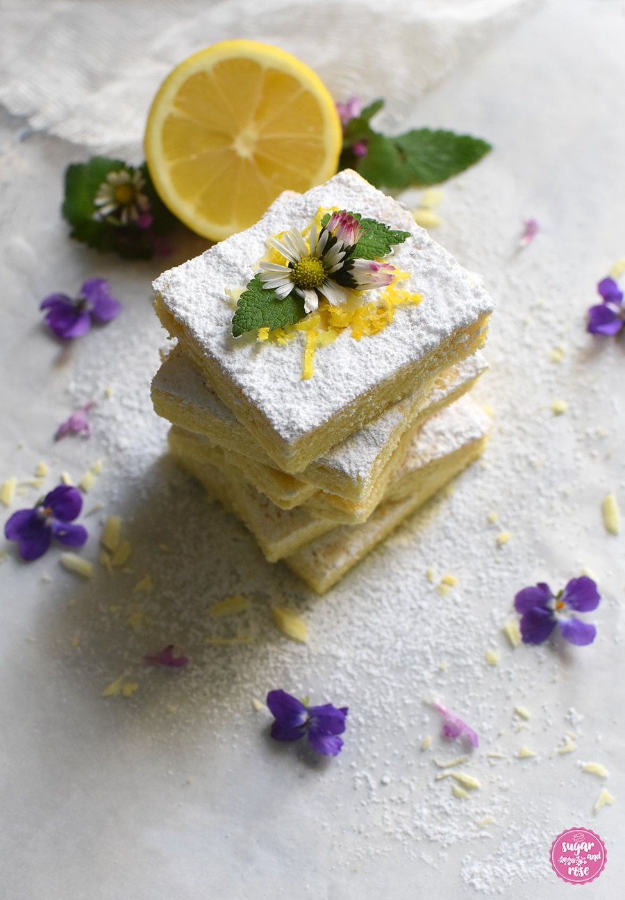 Lemonies mit Puderzucker, Gänseblümchen und Veilchen und einer halben Zitrone