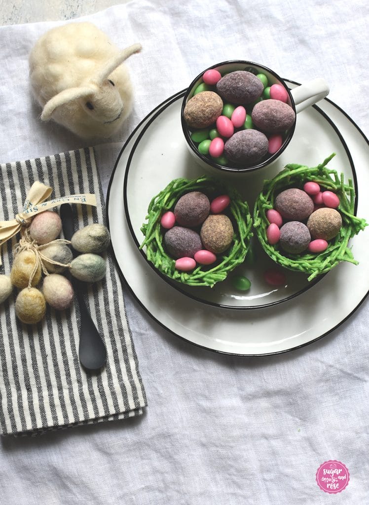 Zwei Osternester mit Lindt-Eiern gefüllt und einem Dekoosterhasen aus weißer Wolle