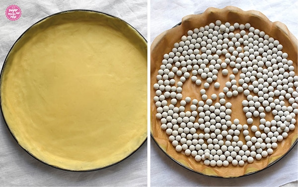 Mürbteig im Rohzustand in einer runden Tartform und daneben mit Backtrennpapier und Keramik-Backbohnen belegt 