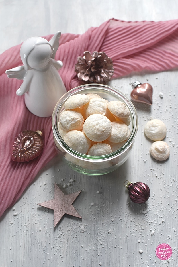 Kokosbusserl in einem Weckglas, dahinter ein rosa Schal, ein weißer Keramikengel und rosefarbener Weihnachtsschmuck