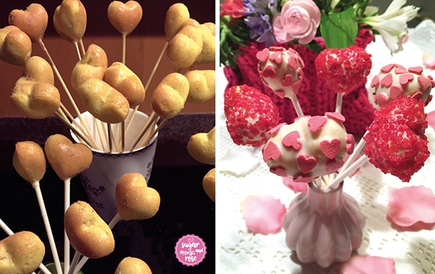 Links herzförmig gebackene Cake-Pops auf Holzstäbchen in einem Keramik-Becher stehend – bereit zum Verzieren; rechts daneben die getunkten und mit rosa Zuckerperlen und rosa Dekoherz-Streuseln dekorierten fertigen Herz-Cake-Pops in einer kleinen rosa Vase, dahinter ein Blumengesteck in einer pinkfarbenen gestrickten Box