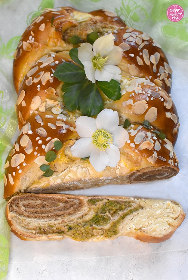 Briochestriezel in der Mitte angeschnitten, davor ein Stück Striezel (Hefezopf) liegend mit gut sichtbaren drei Füllungen