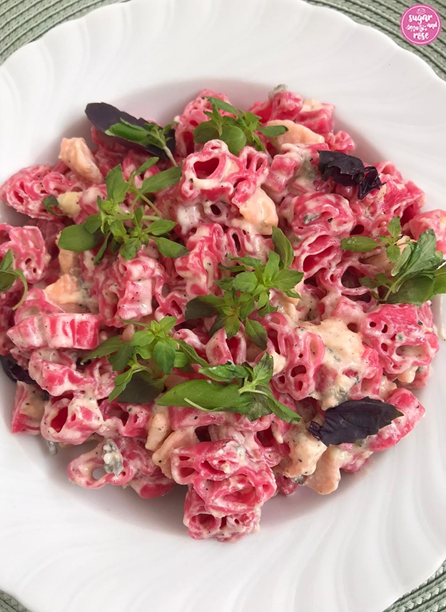 Rosa Pasta in Häschenform mit Lachs und Gorgonzolacreme, dekoriert mit grünem und rotem Basilikum