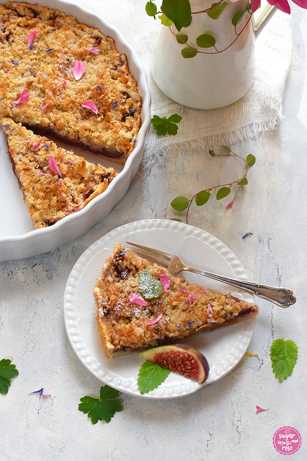 Zwetschken-Feigen-Streuselkuchen in weißer runder Form, angeschnitten