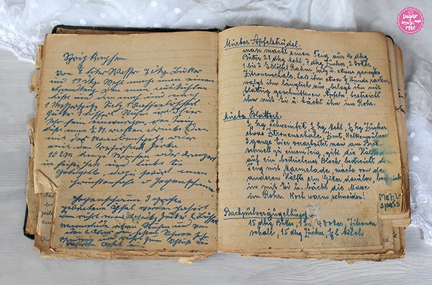 Omas handgeschriebenes, altes Kochbuch mit abgegriffenen linierten Seiten, geschrieben in Kurrentschrift mit blauer Tinte.