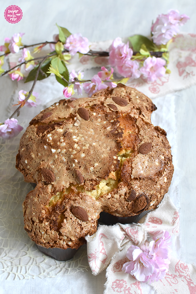 Colomba Pasquale in Papierform auf weißem Leinen und mit breiter Leinenschleife, dekoriert mit rosa Kirschblütenzweig