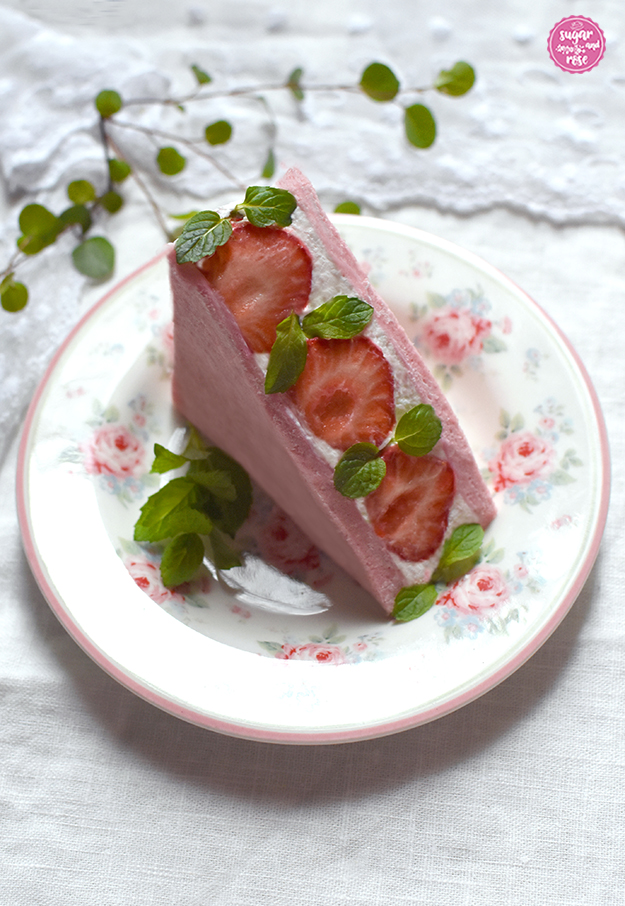 Rosa Erdbeer-Sandwich dekoriert mit grüner Zitronenmelisse auf einem mit Rosen verzierten Dessertteller