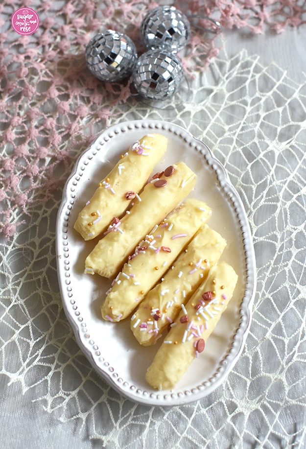 Eierlikör-Kokosstangerl mit weißer Schokolade und rosa-goldenen Zuckerstreuseln
