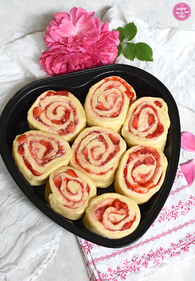 Erdbeerherz-Teiglinge: acht Erdbeer-Hefeschnecken in schwarzer Herzbackform