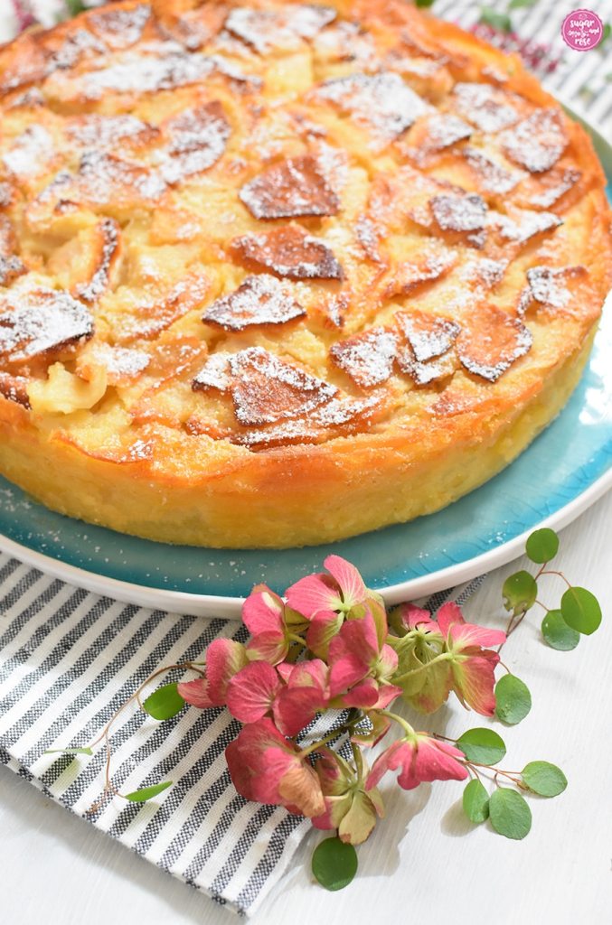Apfelkuchen all'italiana in Großansicht, davor eine rosa Hortensienblüte