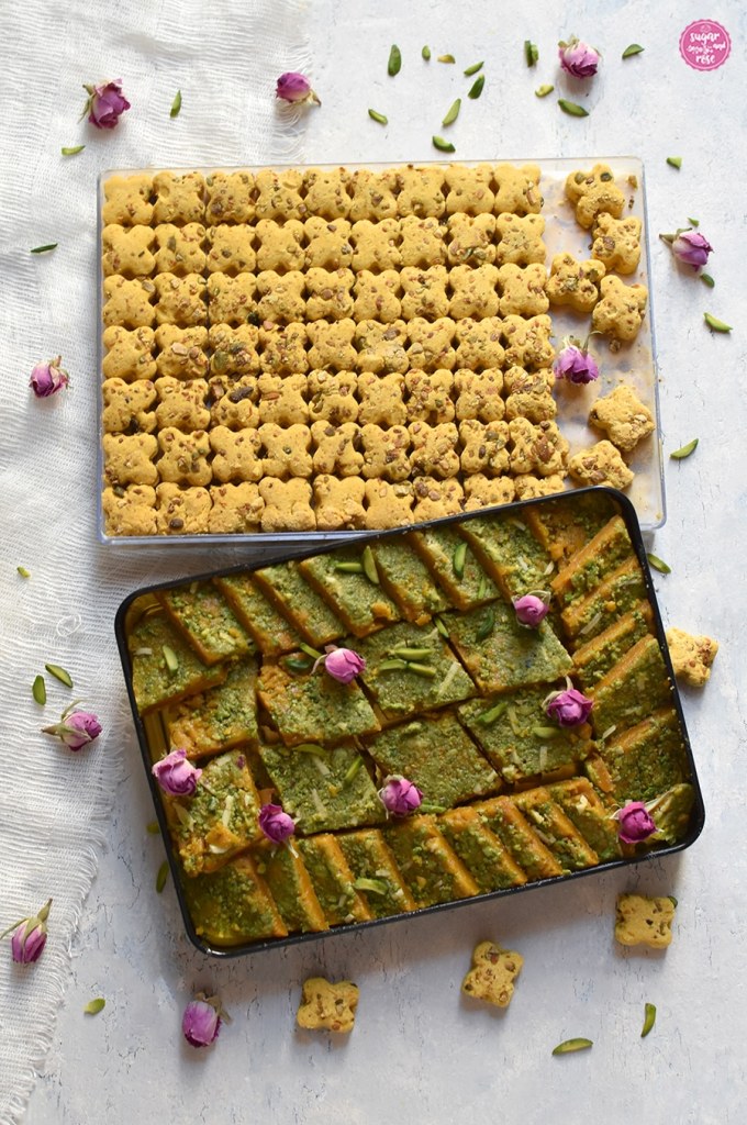 Kichererbsen-Kekse auf durchsichtigem Tablett, davor eine Metallbox mit Kichererbsenkeksen mit grünen Pistazien