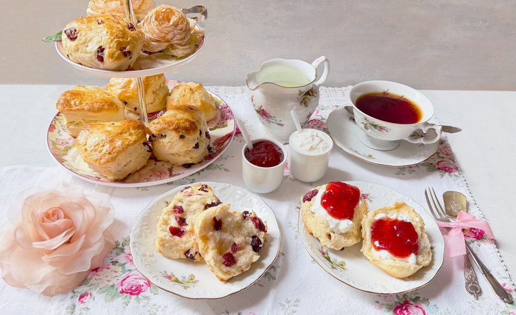 Scones-Herzen auf Etagere mit Cream, Erdbeermarmelade und Tee